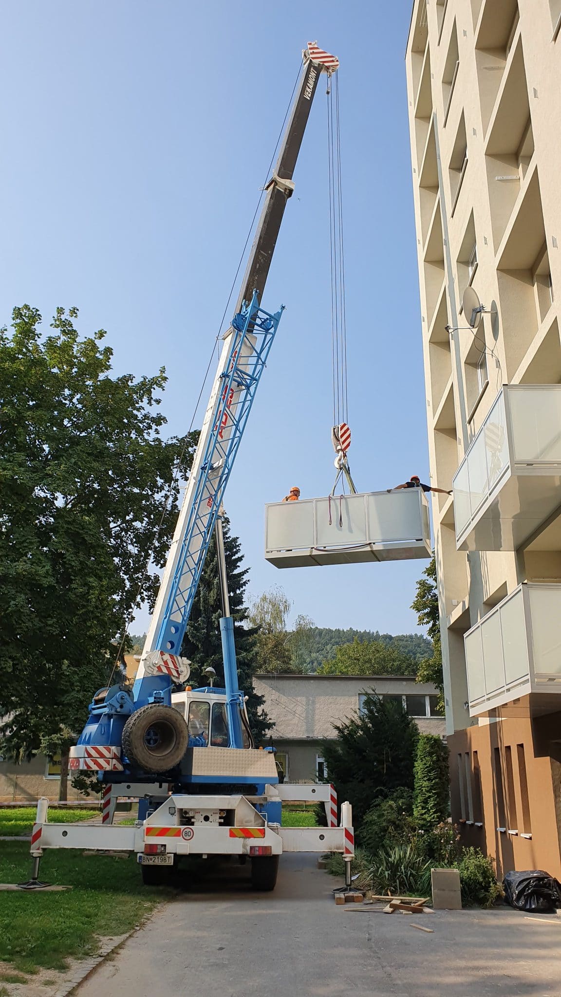 Autožeriav VEKAMONT dvíha balkónový modul k bytovému domu